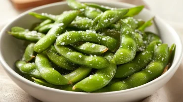 Leckere, knusprige Edamame im Airfryer, perfekt gewürzt für einen gesunden Snack.