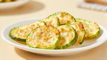 Knusprige Zucchini-Chips, frisch zubereitet im Airfryer für einen gesunden Snack.